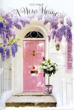A softly lit East Dulwich doorway is captured here as if frozen in the tender pause before someone turns the key and walks into their new life. The door itself is painted a delicate pink, the kind of shade that suggests warmth and kindness without shouting for attention, and it stands calmly against clean whitewashed walls. These walls, with their faintly uneven surface, hold the light in a way that adds quiet character, much like the varied façades that line Lordship Lane and the surrounding residential streets. To one side, a pastel shutter hints at an interior window, its simple lines contributing to the sense of order and ease. Overhead, generous swathes of lavender wisteria pour down from above the frame, the blossoms forming loose, dreamy clusters that drape across the scene. The petals vary in intensity, with some bunches richly coloured, others washed in lighter lilac where the sun grazes their edges, giving the impression of gentle movement even in stillness. Nestled at the foot of the door is a grey metal bucket, placed squarely on the step. It is filled with white and cream roses that appear freshly arranged, their petals thick, soft, and slightly ruffled at the edges. A few buds are just beginning to open, suggesting days of enjoyment ahead, while sprigs of fresh green foliage weave discreetly between the blooms, creating a pleasing contrast. Around the bucket's base, a blush pink ribbon has been tied into a small, careful bow, echoing the hue of the door and adding a last, affectionate touch. The overall mood is calm, optimistic, and deeply welcoming, perfectly suited to congratulating someone on a new flat near Goose Green or a family home a short walk from Peckham Rye, where flowers at the threshold say welcome home long before any furniture finds its place inside.